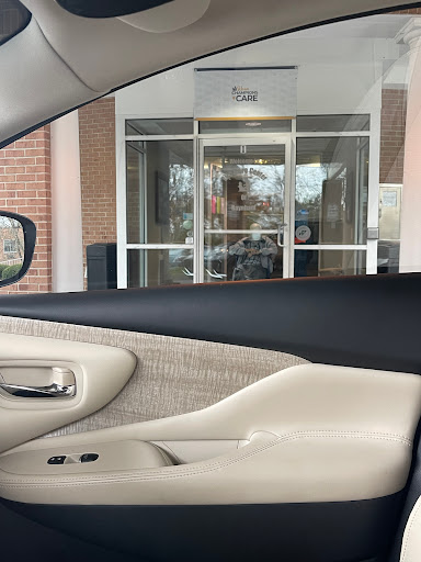 View from inside a car showing the entrance of a building.