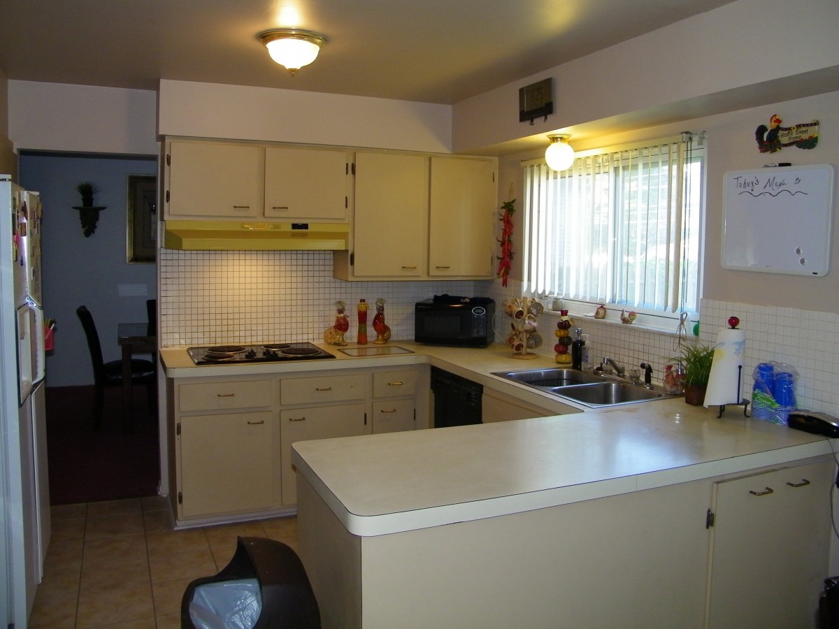 A small kitchen with cream-colored cabinets and a cozy setup.