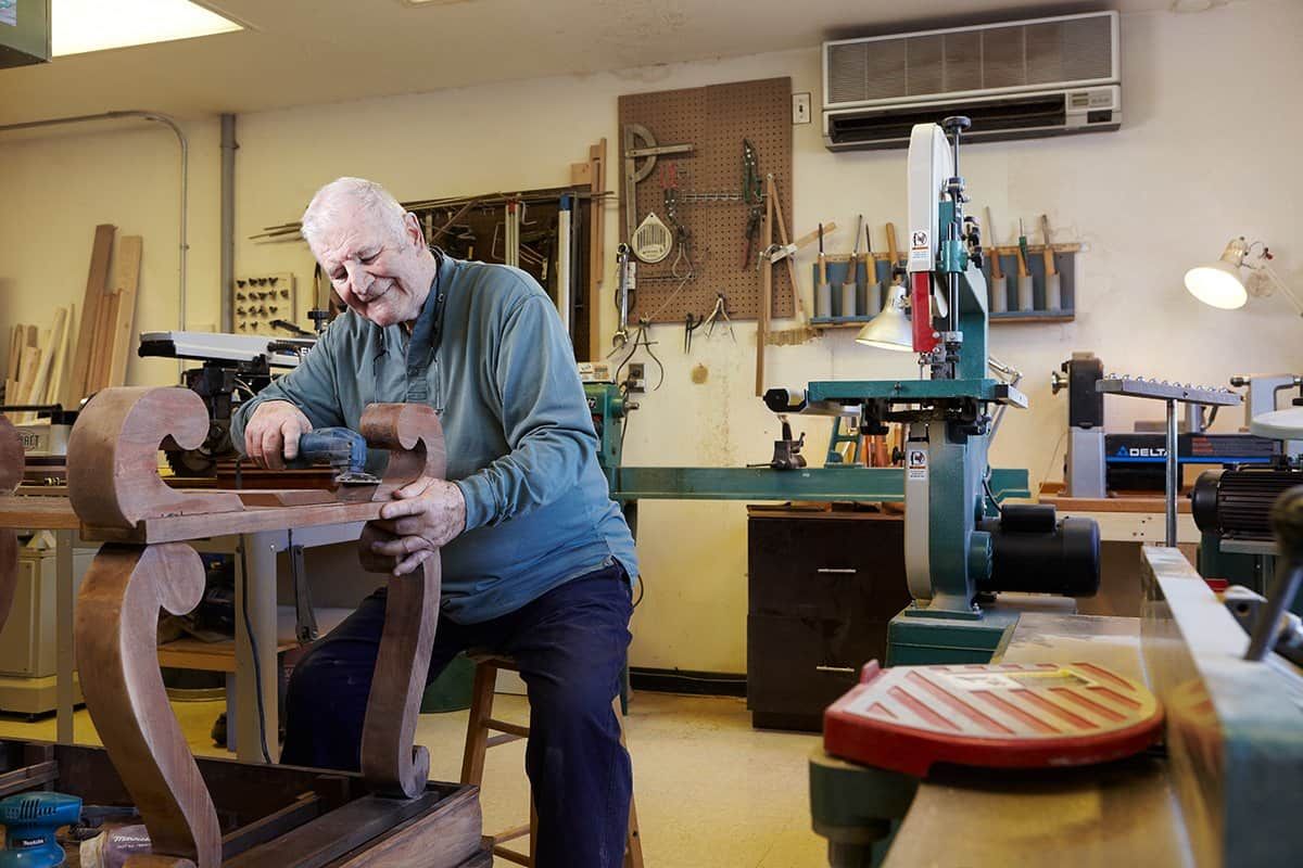 A craftsman working on a woodworking project in a well-equipped workshop.