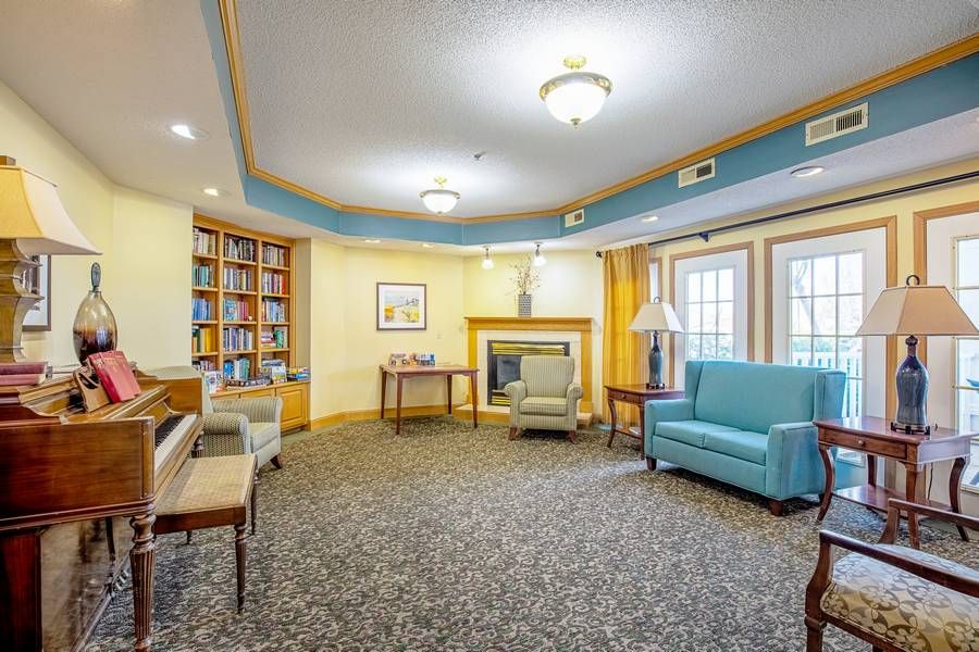 A cozy living room with a fireplace, comfortable furniture, and a bookshelf.