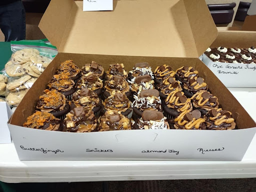 A tempting assortment of delicious cupcakes topped with various chocolates and drizzles.