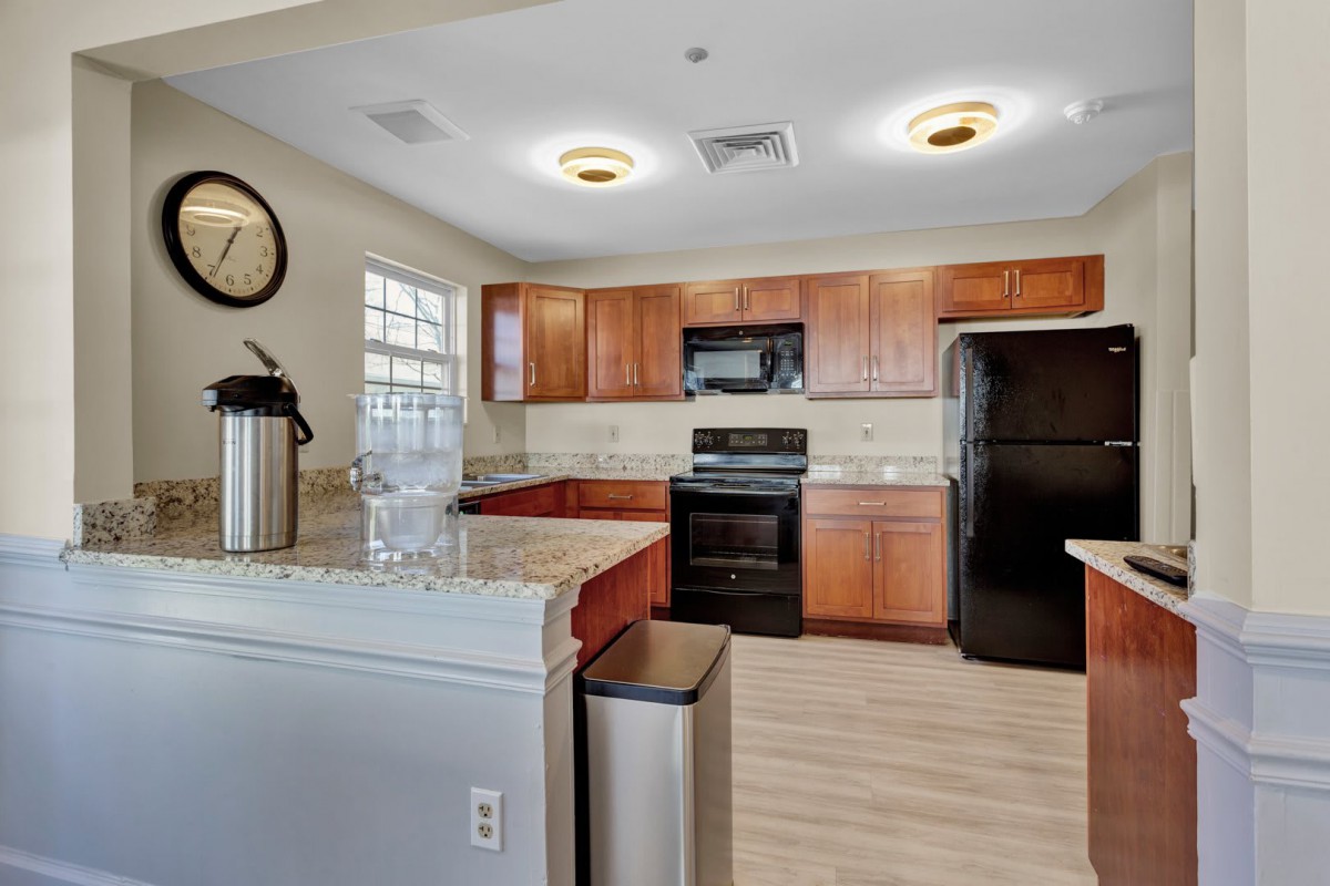 A modern kitchen interior with wooden cabinets and essential appliances.