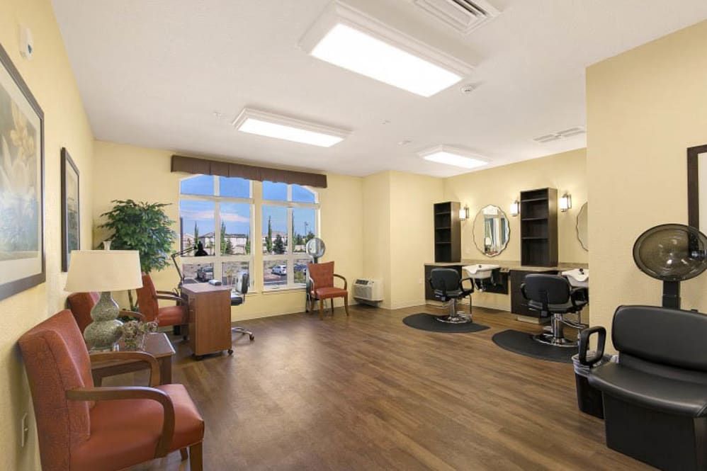 A well-lit salon interior with chairs, mirrors, and large windows.