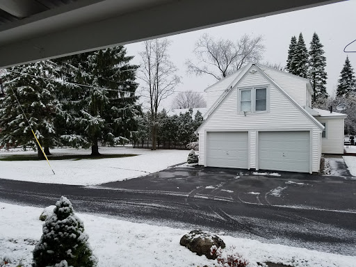 A serene winter scene with snow covering the ground and trees, showcasing a beautiful house in the background.