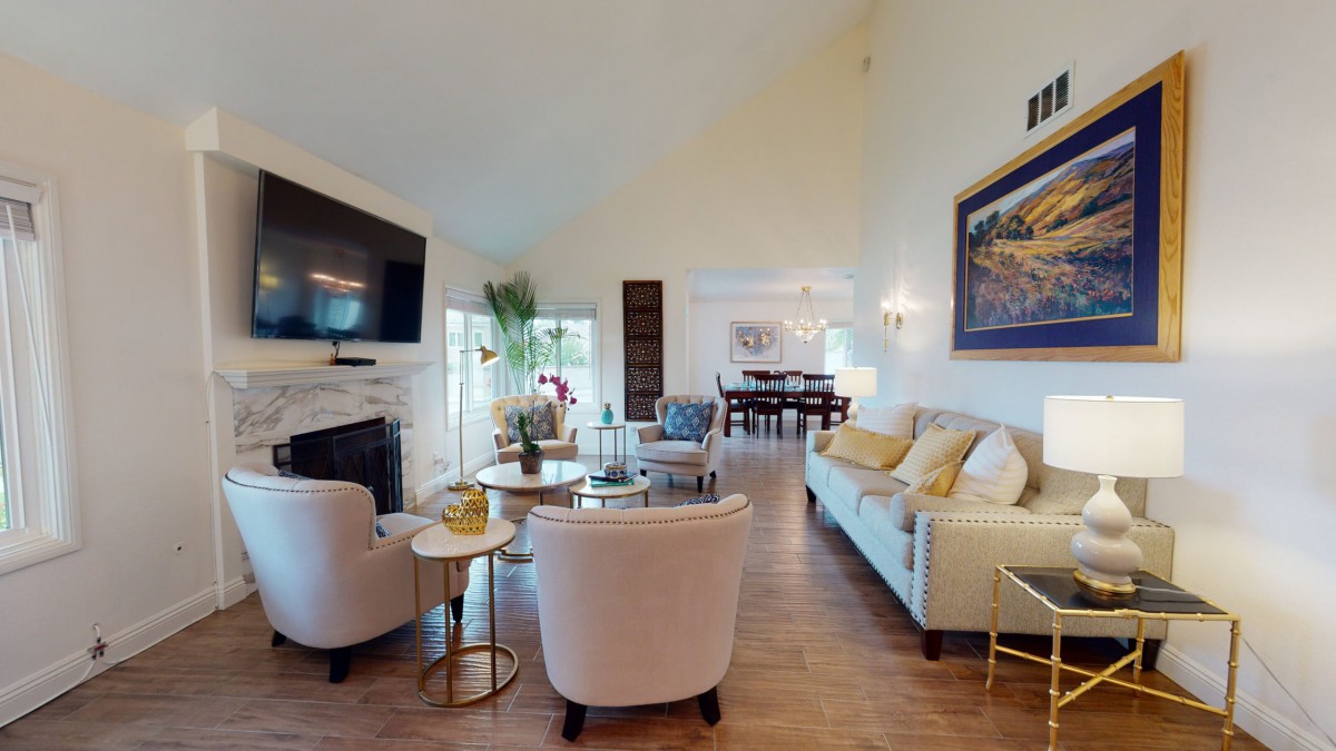 A stylish living room with comfortable seating, modern decor, and a connected dining area.