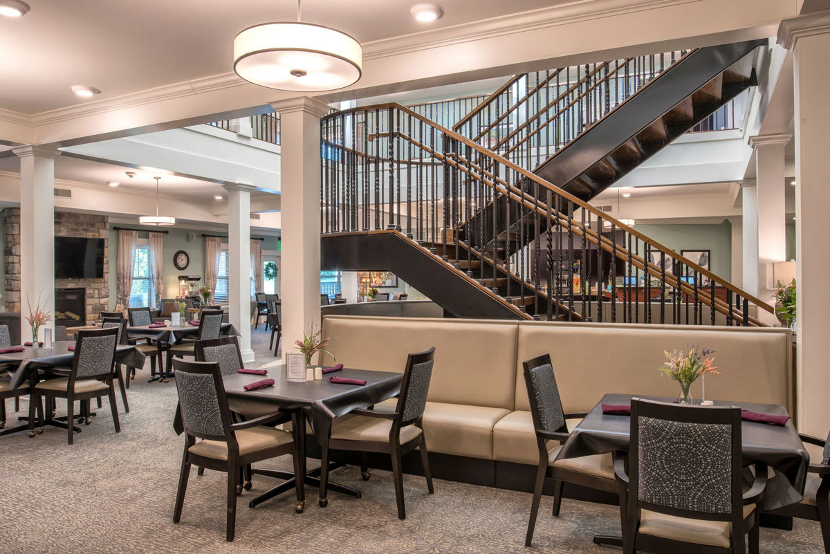 A modern dining area with elegant seating and a stylish staircase.