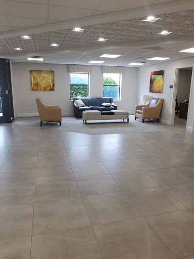 A spacious and modern lobby featuring comfortable seating, contemporary artwork, and ample natural light.