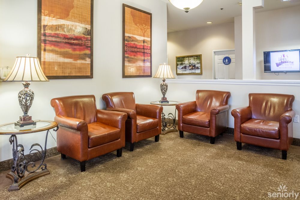 A cozy waiting area featuring leather armchairs and abstract artwork on the walls.