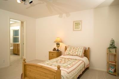 A simple bedroom with a single bed and nightstand.