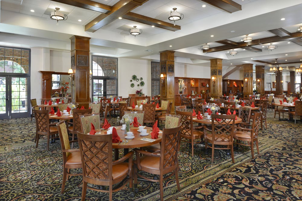 A spacious and elegantly decorated restaurant interior with neatly arranged tables and chairs.