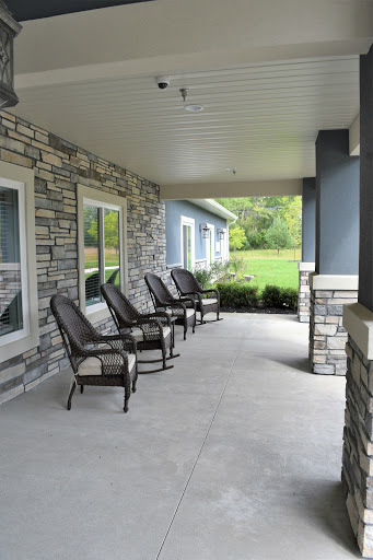 A serene porch area with comfortable chairs overlooking a lush lawn.