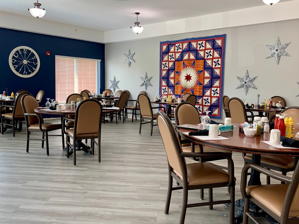 A modern dining room with neatly arranged tables and vibrant wall art.