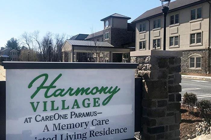 Entrance sign for Harmony Village, an assisted living and memory care facility.