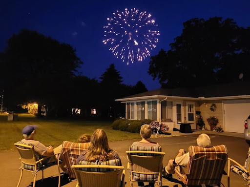 A family enjoying a fireworks display on a warm summer night.