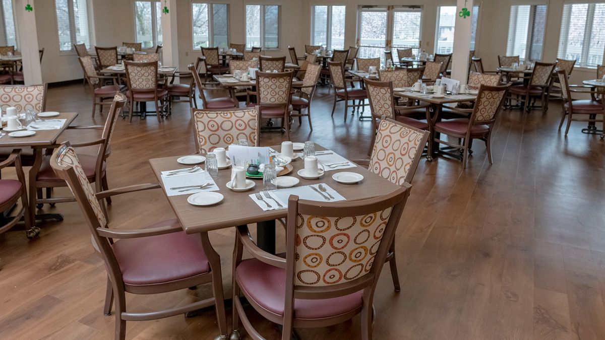 An empty dining room with neatly arranged tables and chairs.