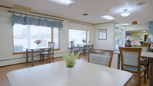 A bright and welcoming dining area with tables, chairs, and decorative plants.