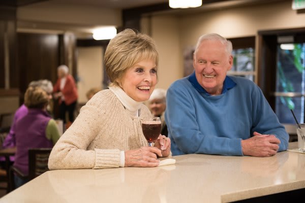 An elderly couple enjoying a pleasant moment together indoors.