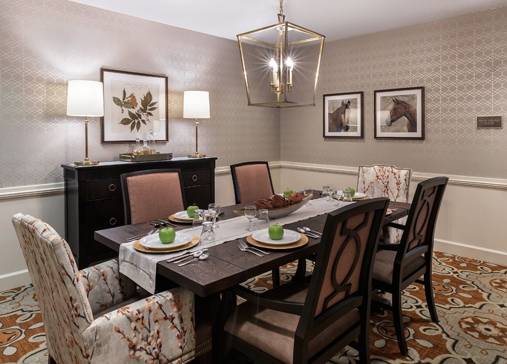 A well-decorated dining room featuring a large table with chairs, elegant lighting, and tasteful artwork on the walls.