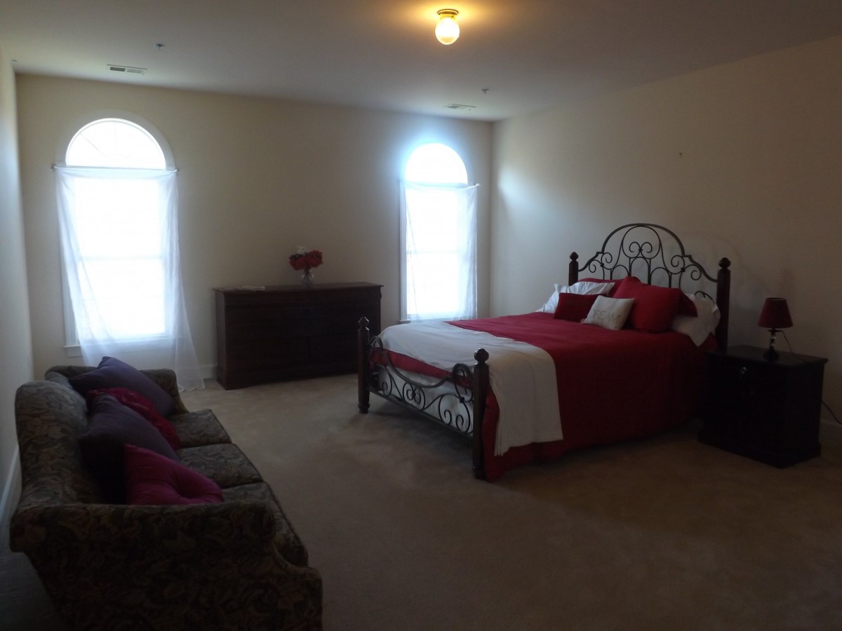 A cozy bedroom with a neatly made bed and simple furniture.