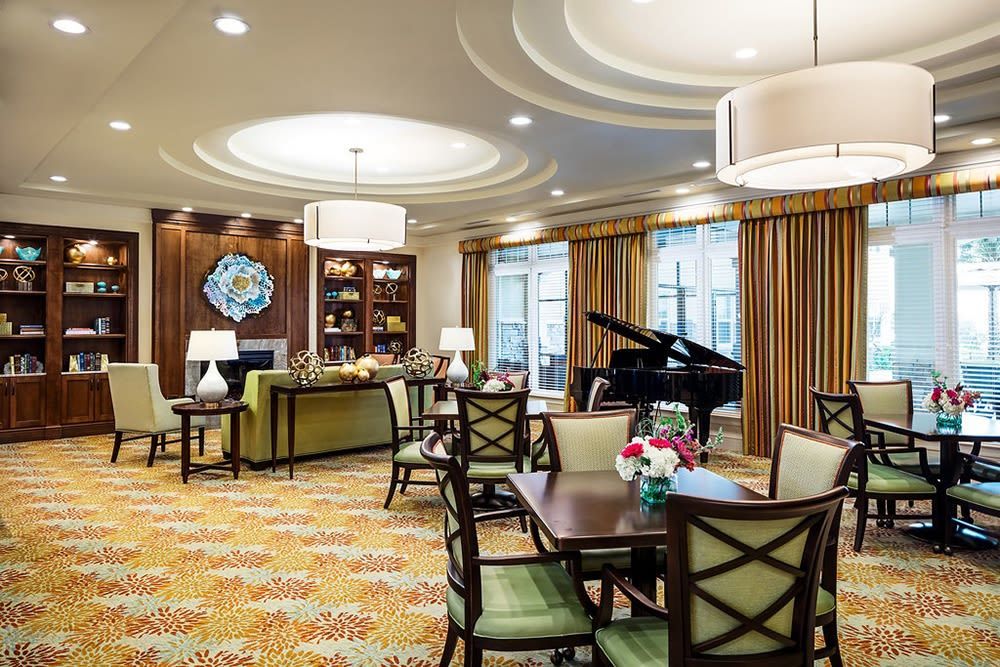 A cozy living and dining area featuring elegant furniture and a grand piano.