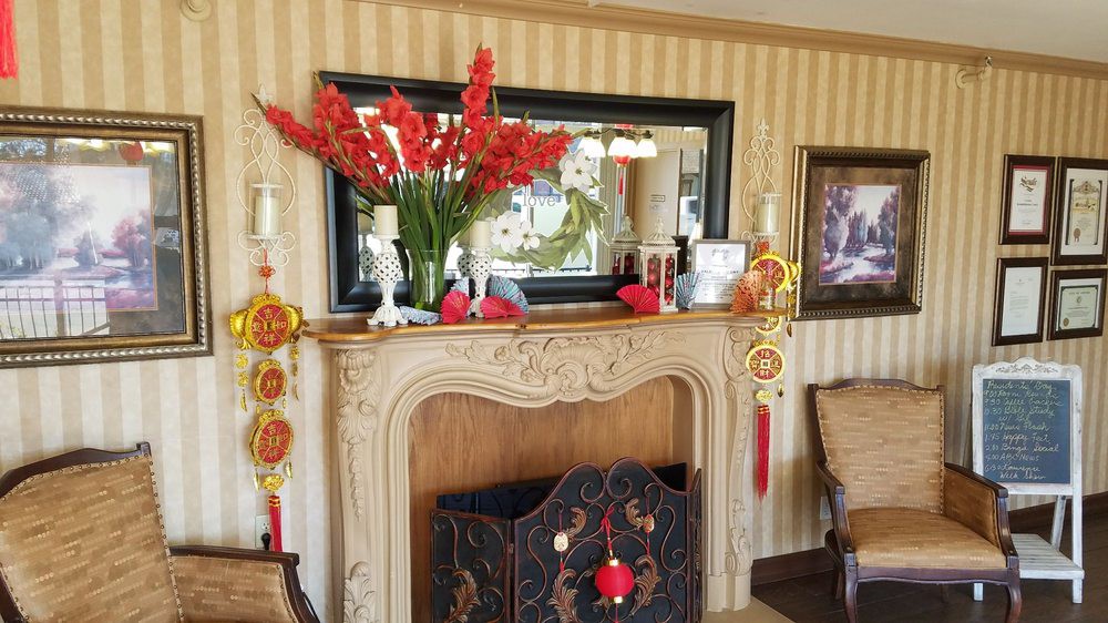 A decorated fireplace with a mirror, flowers, and traditional ornaments.