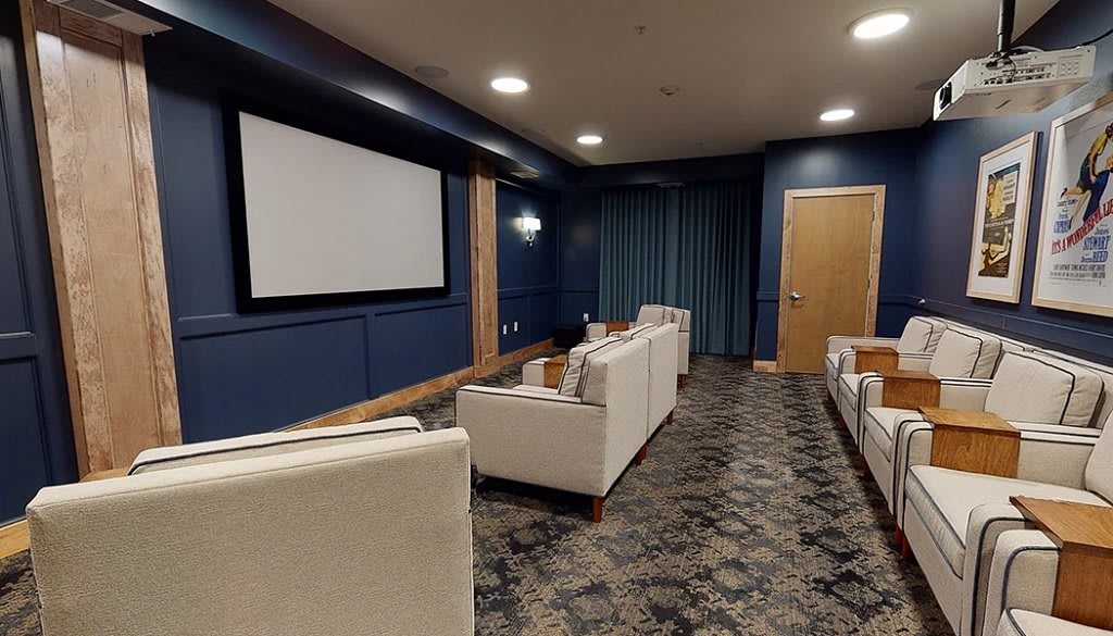A cozy home theater room with comfortable seating and a large screen.