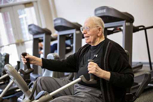 An elderly man enjoys a workout at the gym, demonstrating that fitness is for all ages.