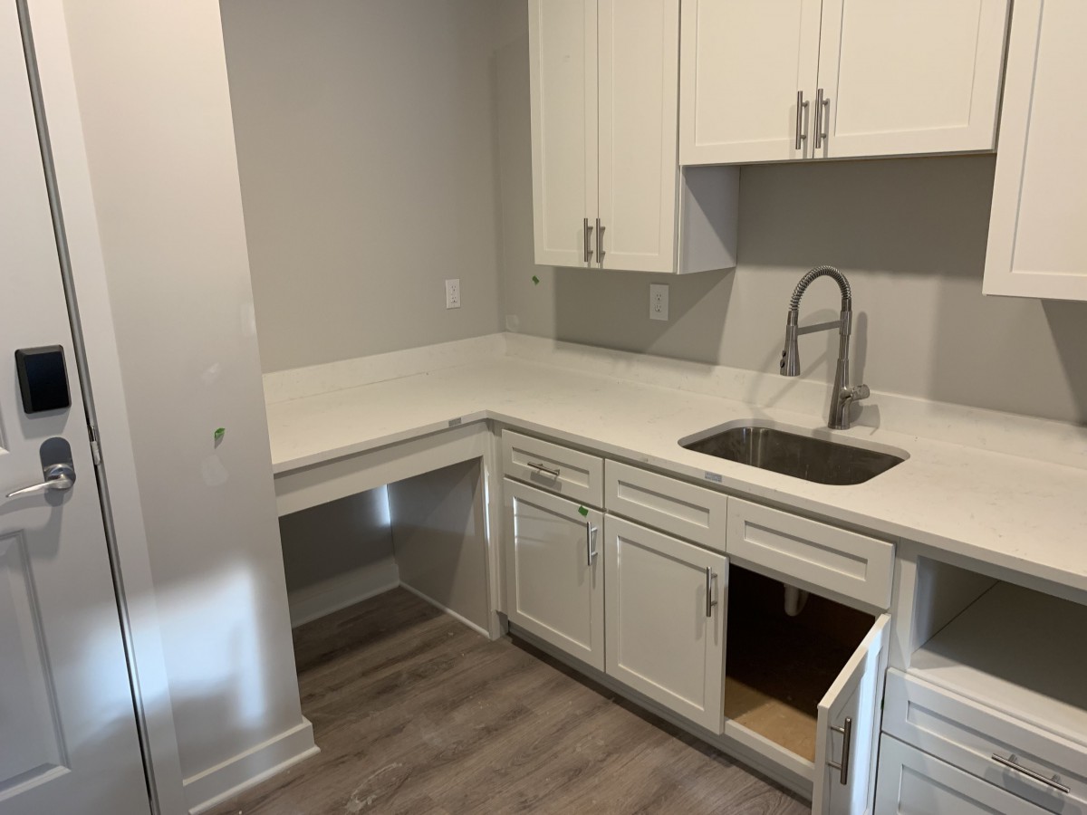 A modern kitchen with white cabinets and a sleek design.