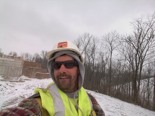 A construction worker taking a selfie on a snowy day.