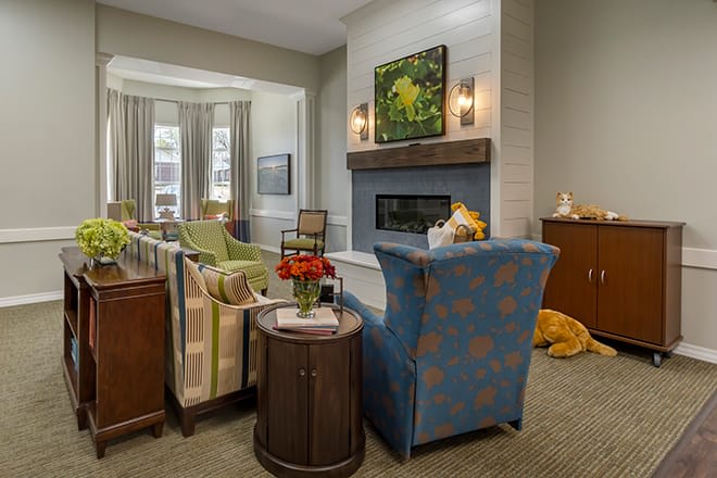 A cozy living room with stylish furniture and a fireplace, adorned with decorative elements.