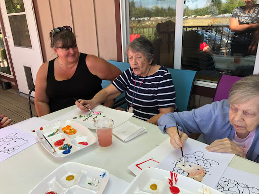 Seniors enjoying a fun painting session together, fostering creativity and companionship.