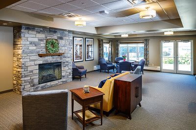 A cozy living room with a stone fireplace and comfortable seating.