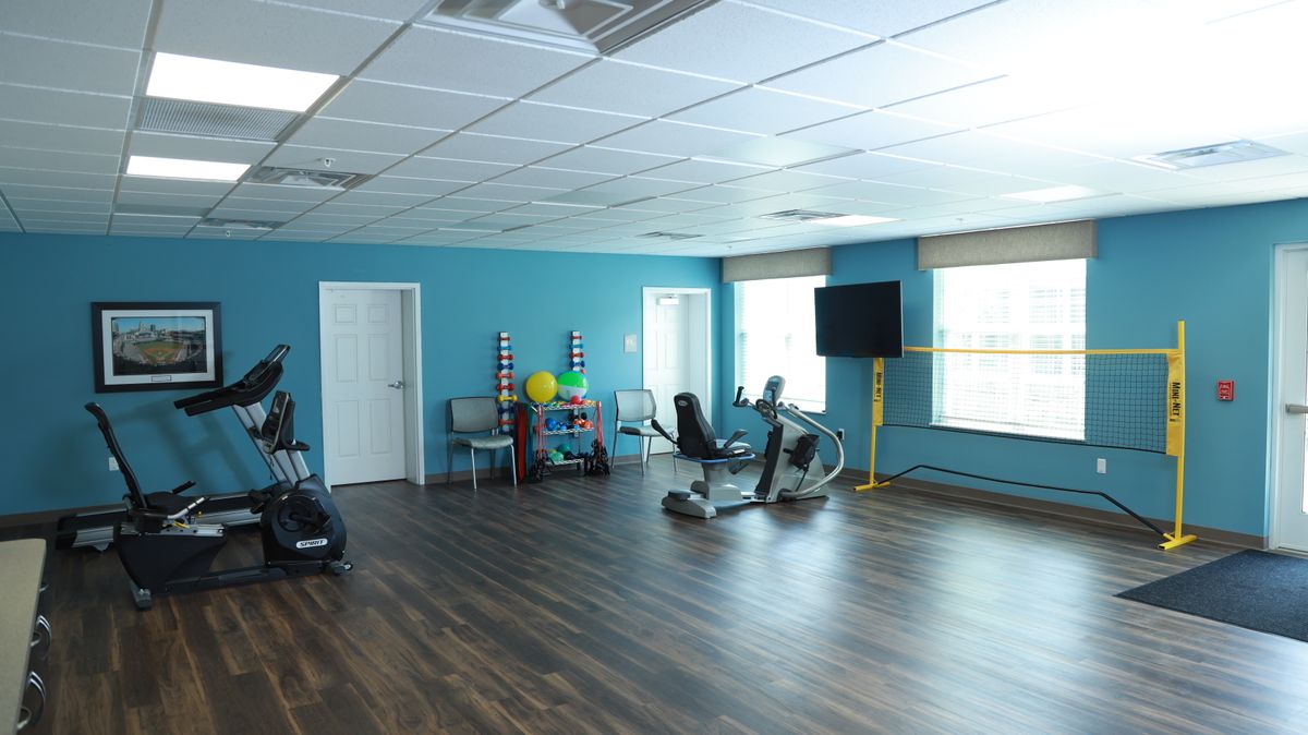 An empty fitness room with exercise equipment and blue walls.