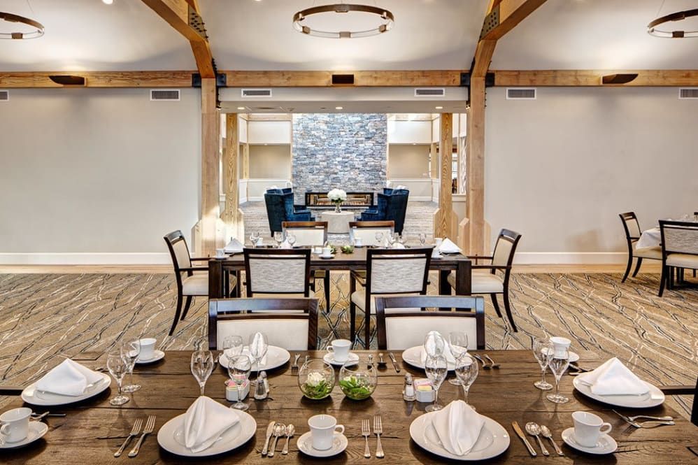 An elegantly set dining area with neatly arranged tables and chairs, showcasing refined interior design.