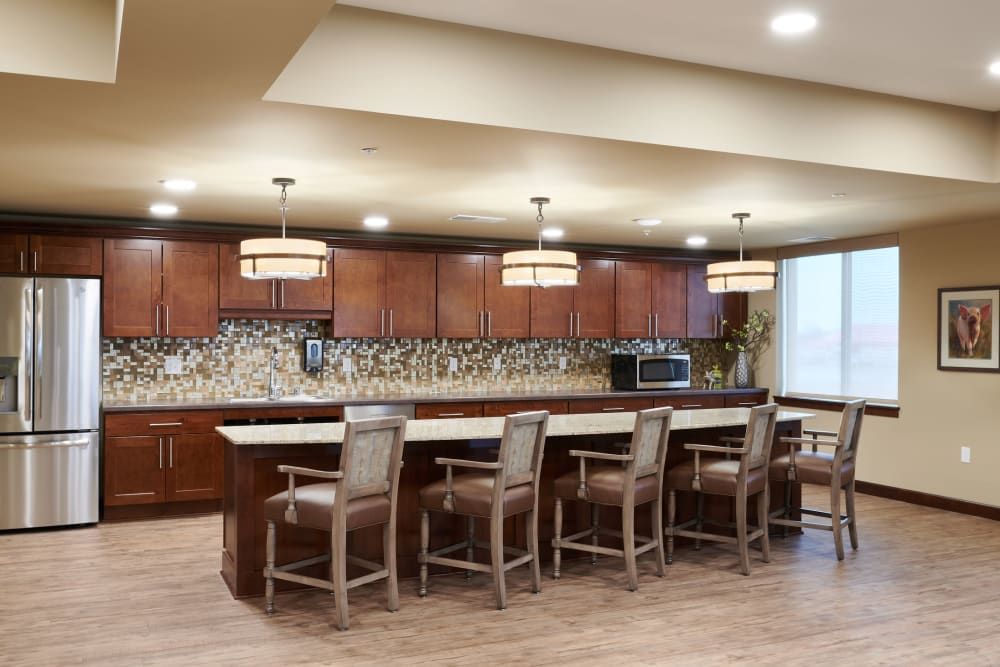 A modern kitchen with a bar counter and pendant lighting.