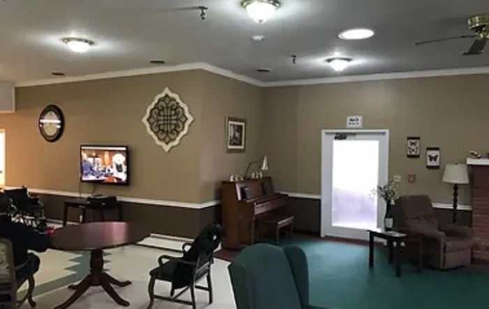 A cozy living room featuring a piano, TV, and comfortable seating arrangements.