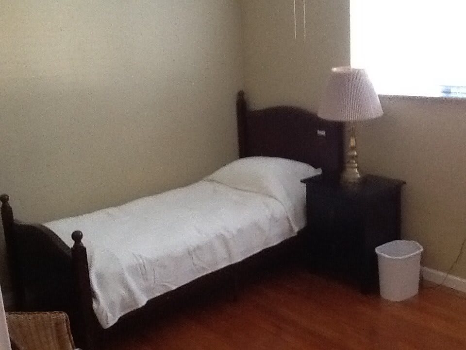 A minimalist bedroom with a single bed and nightstand.