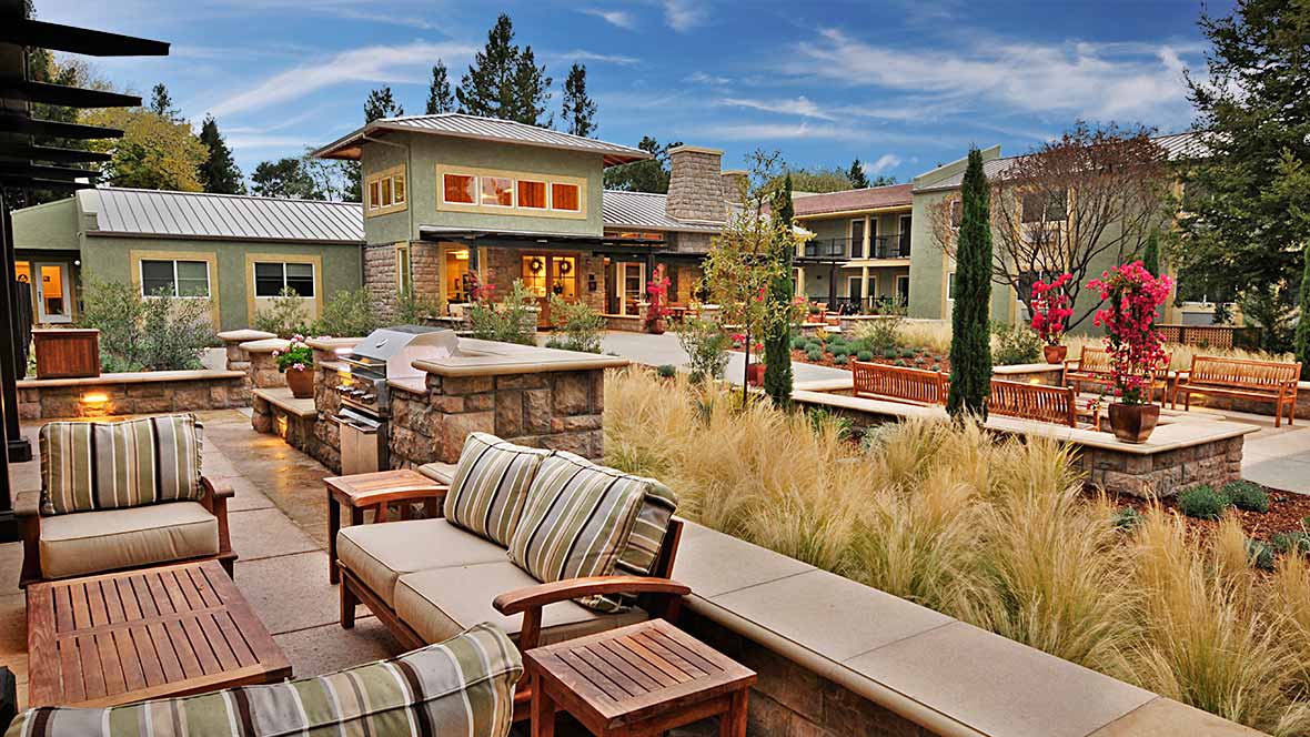 A luxurious modern home with beautifully landscaped gardens and outdoor seating.