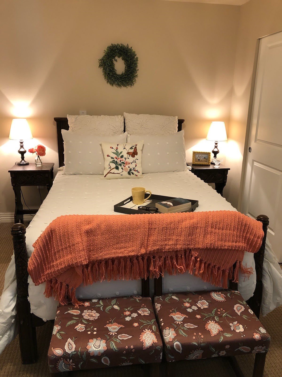 A cozy bedroom setup with an orange blanket and soft lighting.