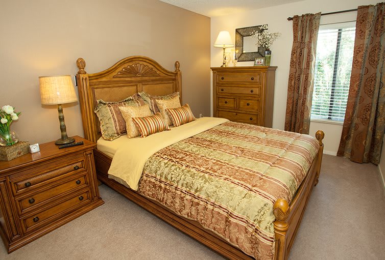 A traditional bedroom with wooden furniture and warm decor.
