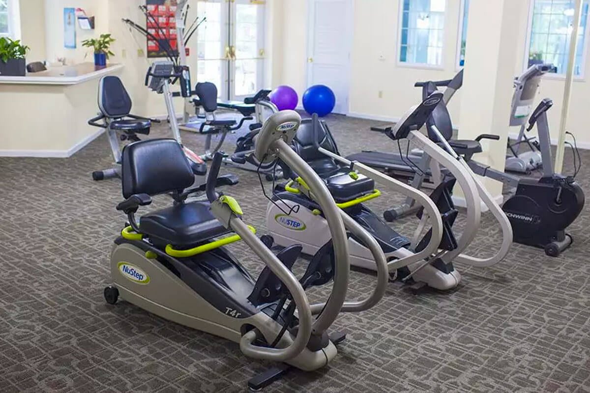A gym room featuring various exercise machines, including recumbent bikes.