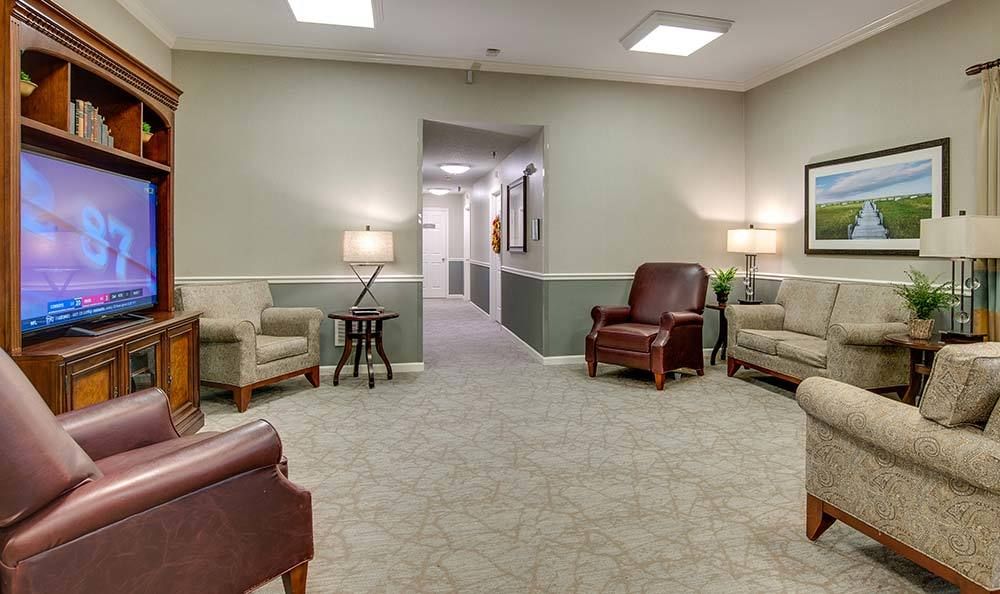 A comfortable waiting room with several chairs and lamps, leading to a hallway.