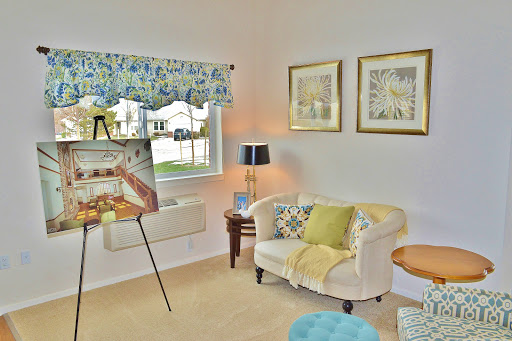A cozy living room featuring a stylish sofa, decorative pillows, an artwork display, and soft lighting.