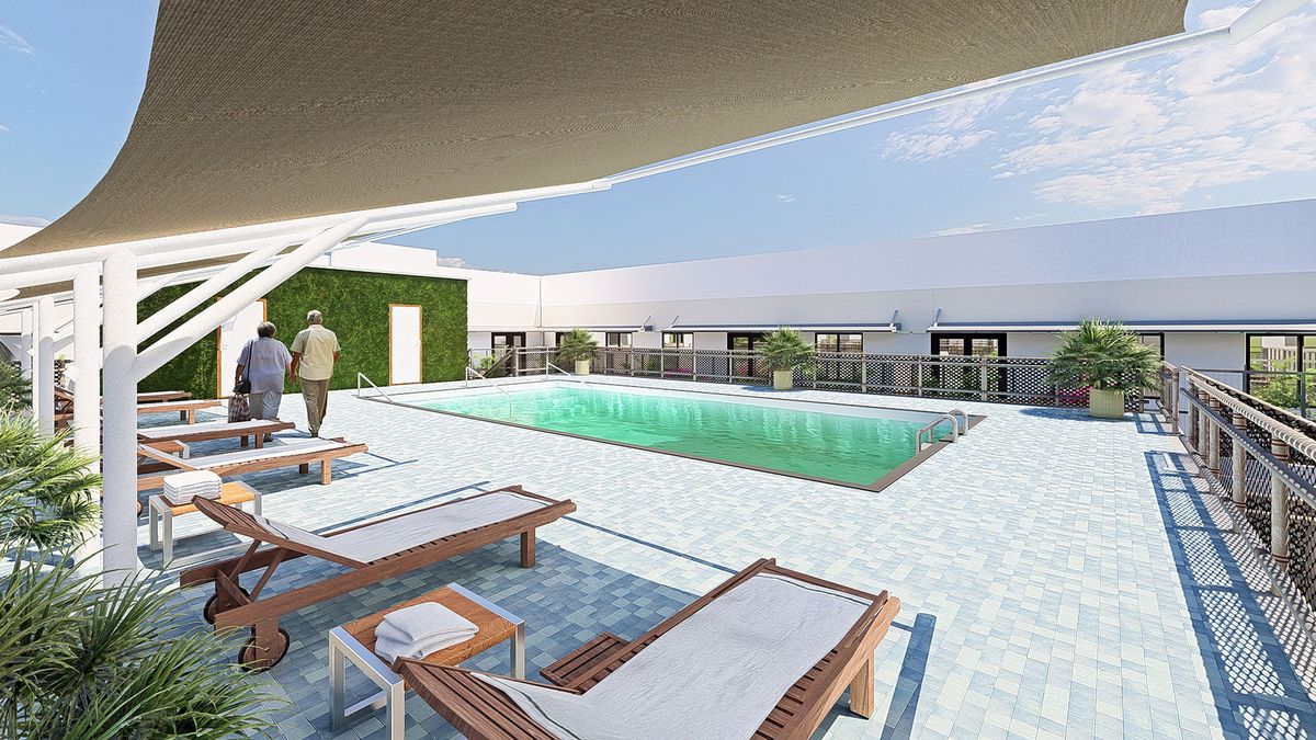 A rooftop swimming pool with lounge chairs and a view of the city skyline.