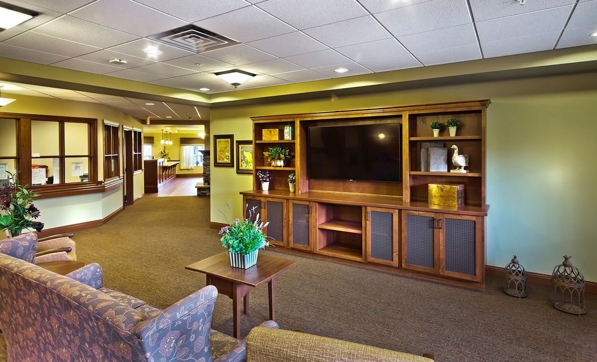 A cozy living room with a large entertainment center and comfortable seating.