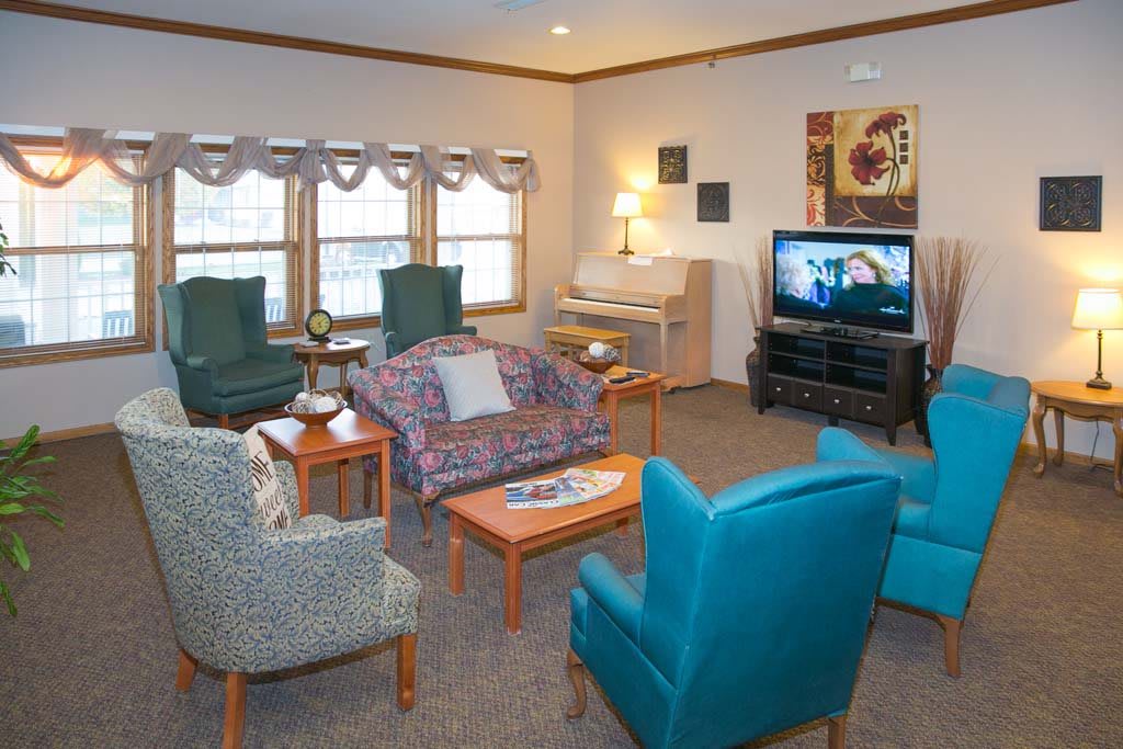 A cozy living room with comfortable seating, a television, and a piano, creating an inviting atmosphere for relaxation.