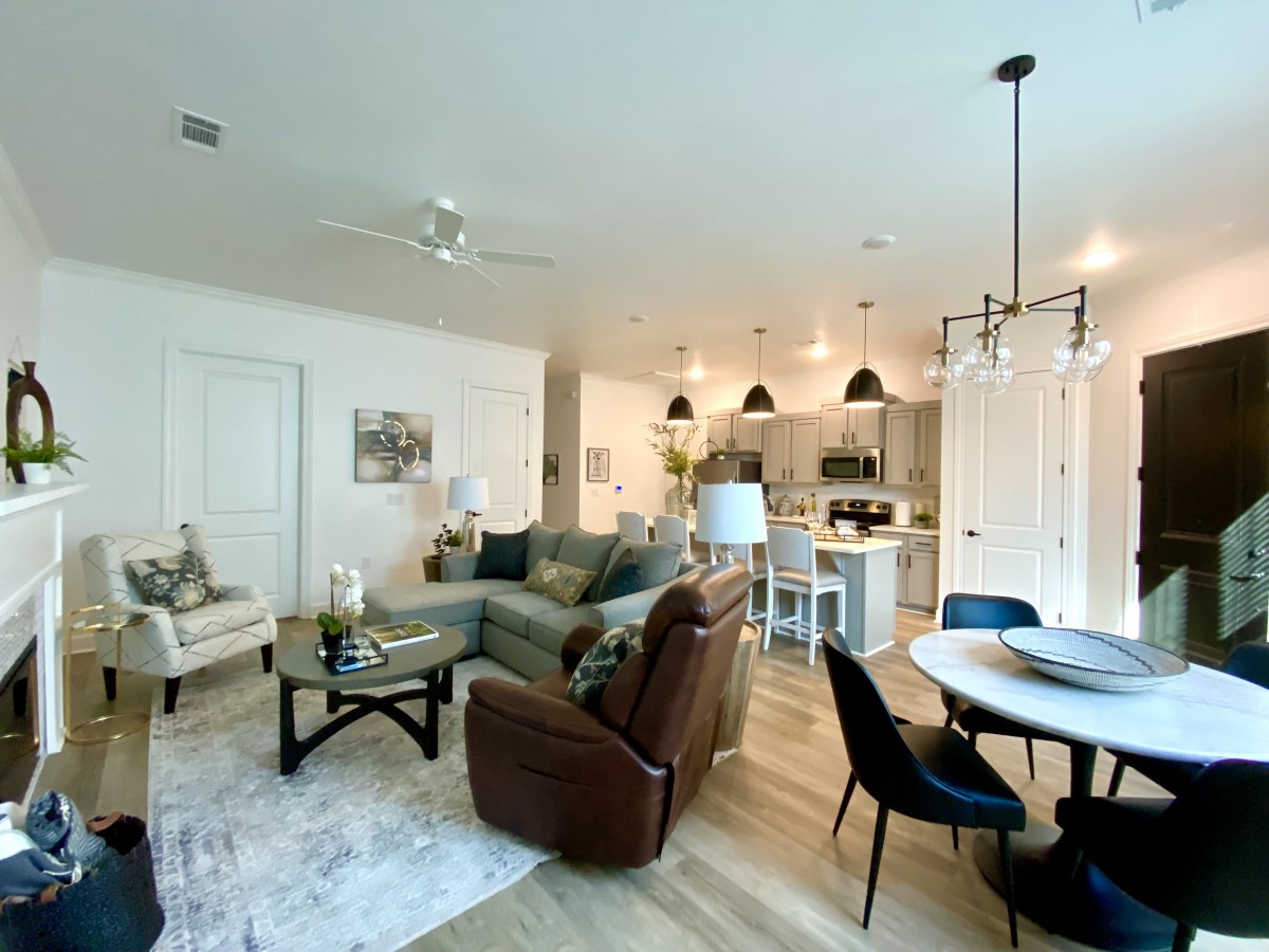 A modern open-plan living space featuring a cozy seating area, stylish kitchen with island, and an elegant dining area.