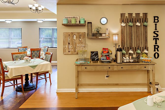 A cozy interior space featuring a dining area and a coffee station with decorative elements.