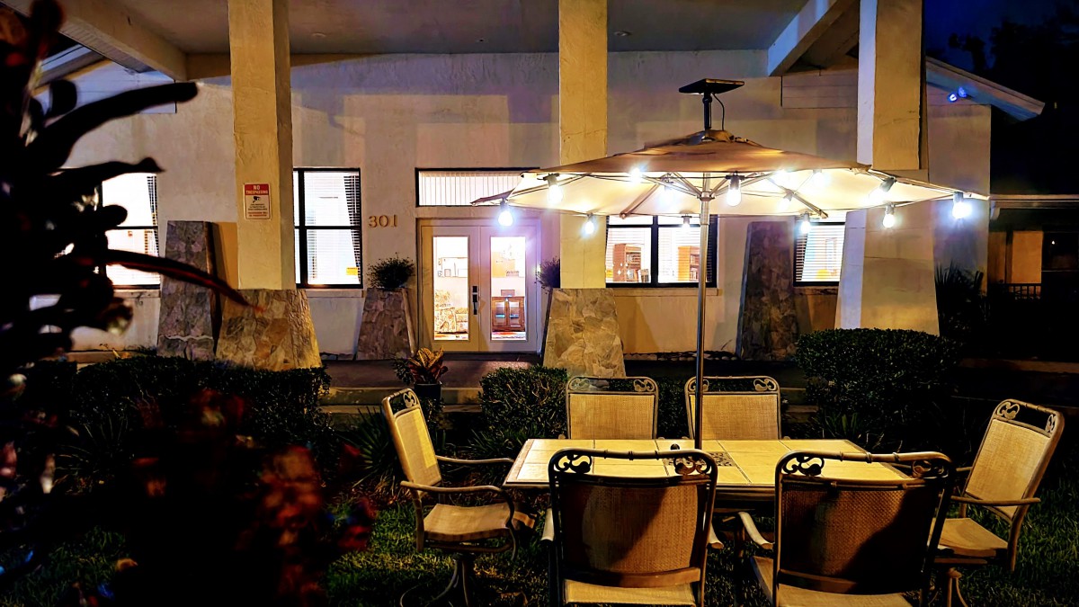Cozy outdoor patio seating area illuminated by warm lights.