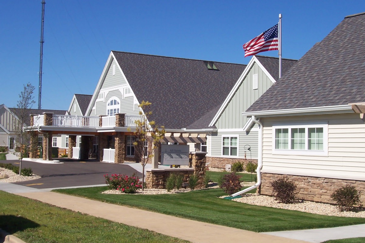 A residential building with a well-maintained lawn and an American flag flying in front.